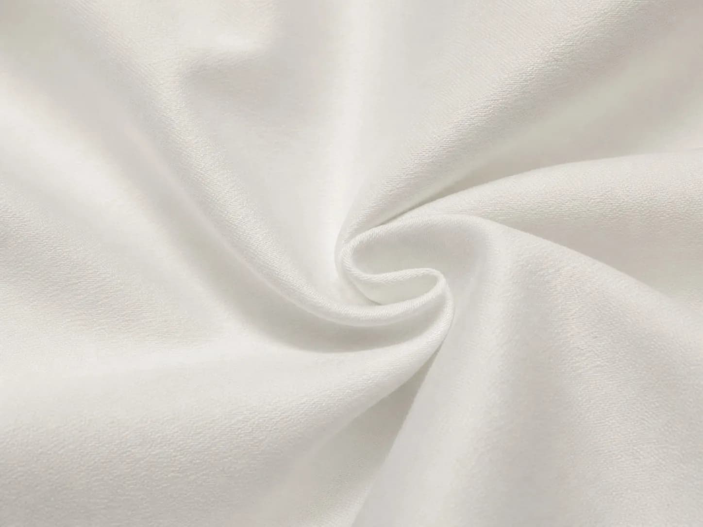 Close-up of smooth white polyester-cotton blend fabric with a fine woven texture