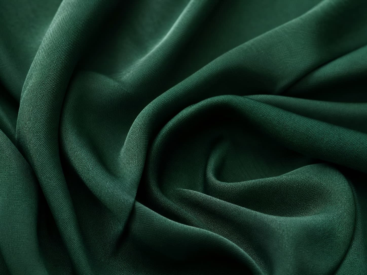 Close-up of fluid forest-green rayon and viscose fabric