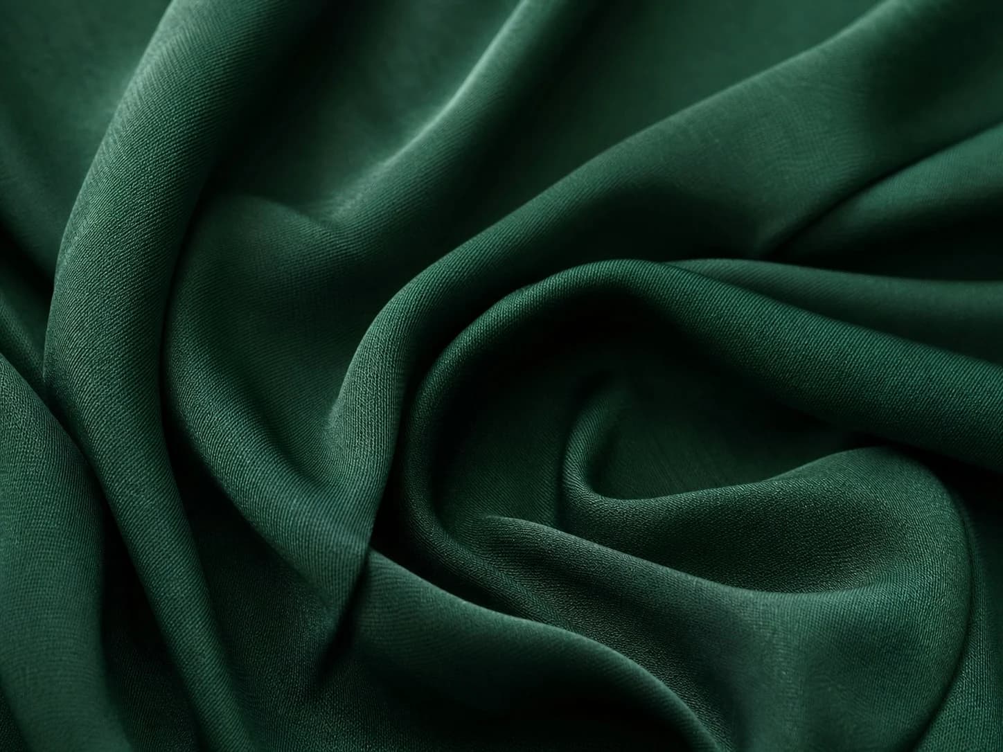 Close-up of fluid forest-green rayon and viscose fabric