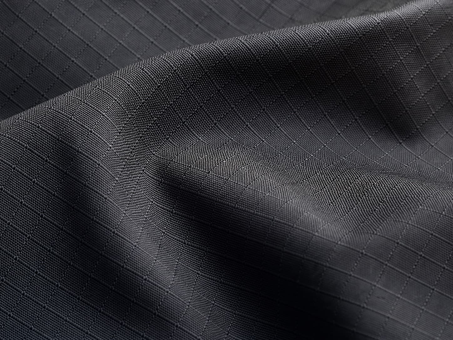 Close-up of charcoal technical textile with a ripstop weave