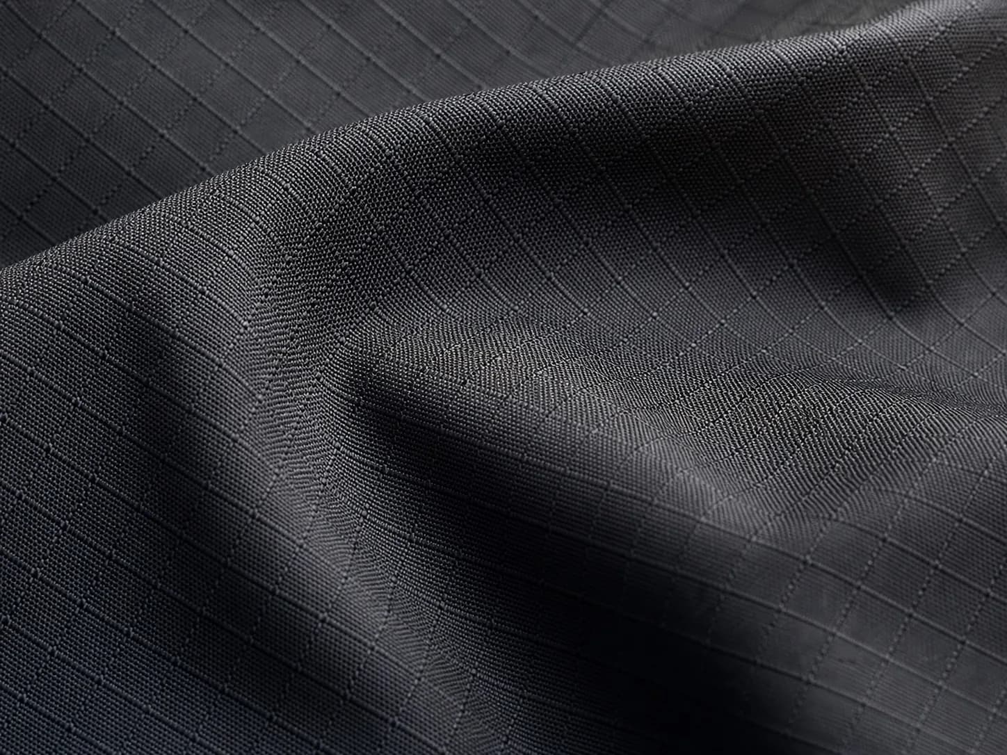Close-up of charcoal technical textile with a ripstop weave