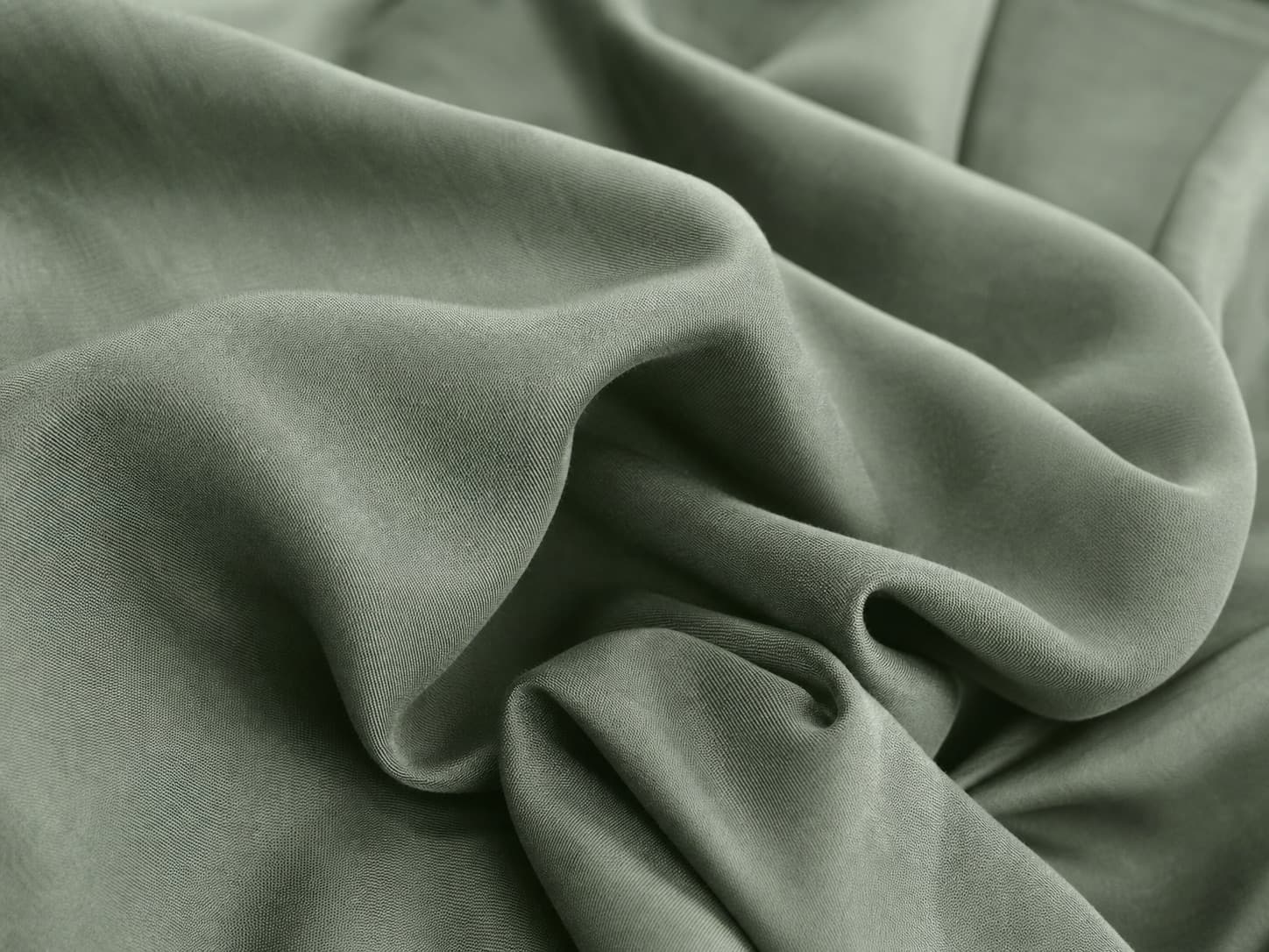 Close-up of softly draped sage-green Tencel fabric