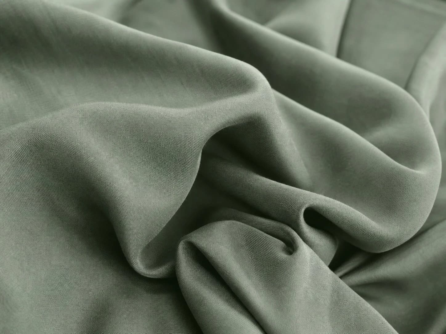 Close-up of softly draped sage-green Tencel fabric